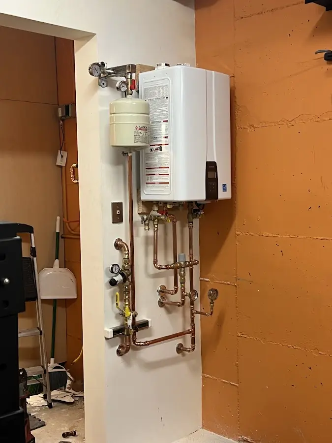 Plumbing technician inspecting water heater connections in Three Rivers